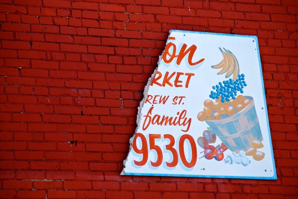 Sign previously read "Kensington Fruit Market: Carlos & family" at the corner of Kensington and St. Andrew, Toronto 2011-05-24